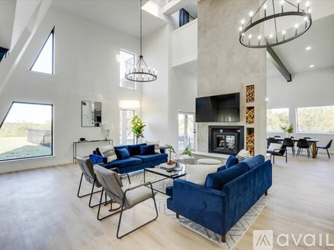 A modern living room with a blue sofa and a fireplace.