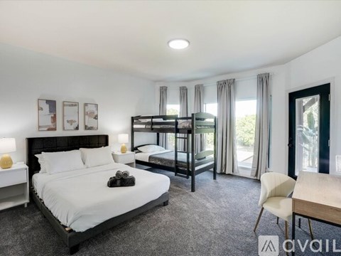 A bedroom with a large bed and a bunk bed.