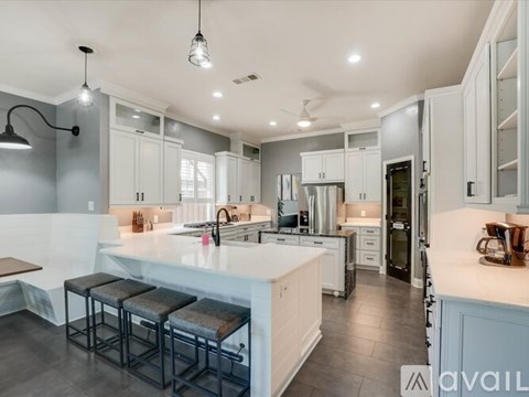A modern kitchen with white cabinets and a central island.