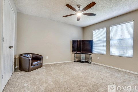 A living room with a brown leather chair and a flat screen TV.