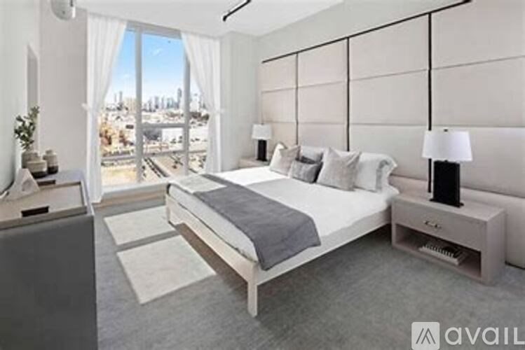 A modern bedroom with a large bed and a view of the city.