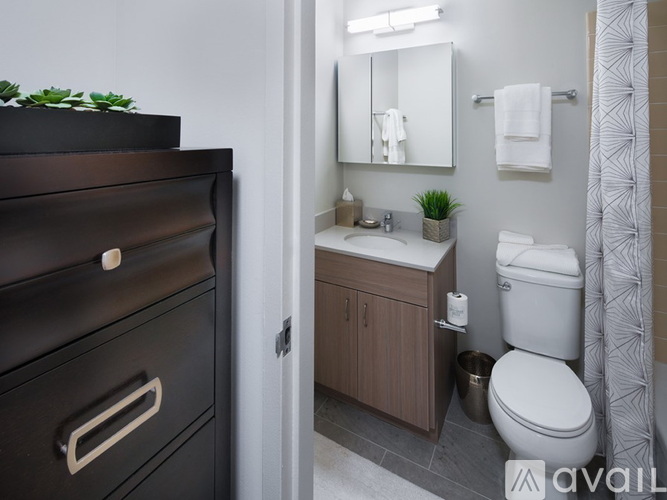 A bathroom with a toilet, sink, and a mirror.