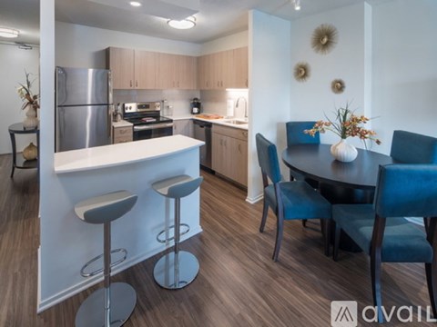 A kitchen with a bar area and a dining table with chairs.