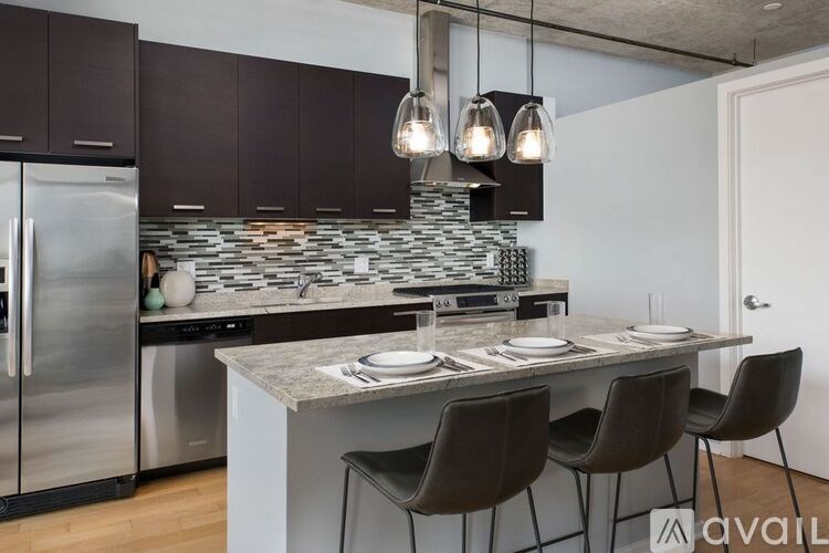 A kitchen with a stone backsplash and a table set for two.