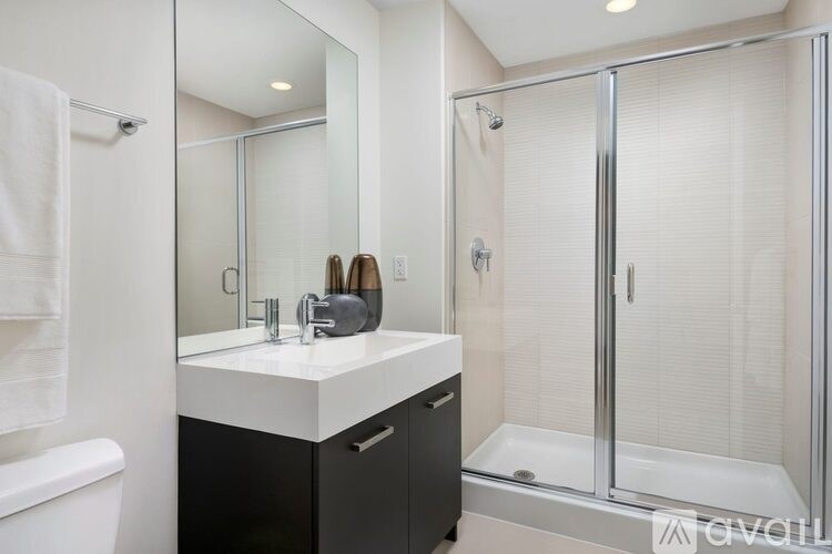 A bathroom with a white countertop and a white towel hanging on the wall.