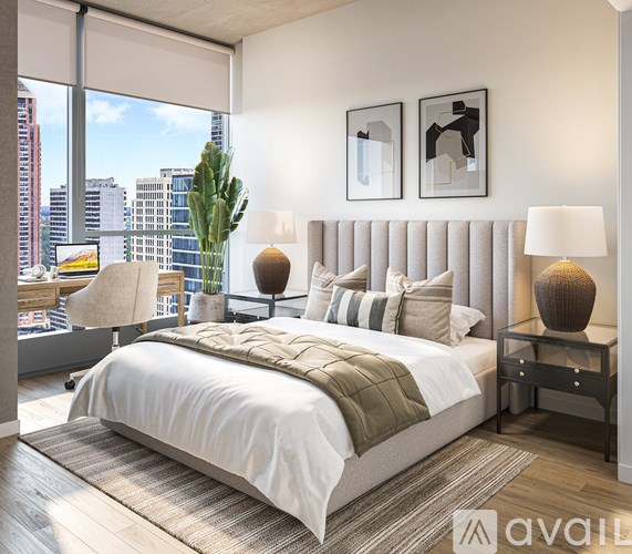 A bedroom with a large bed and a city view through the window.