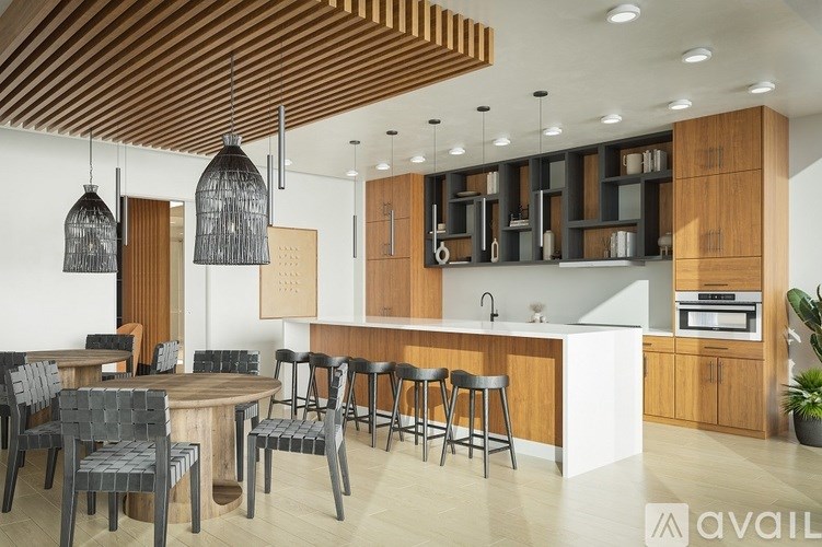 A modern kitchen with a wooden ceiling and a dining table with chairs.