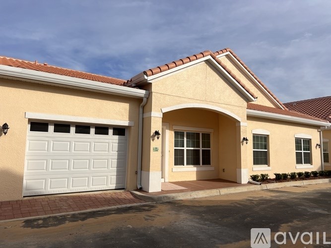 A house with a white garage door and a brown roof.