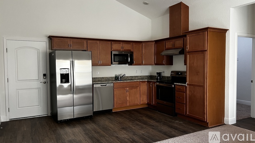 A kitchen with wooden cabinets and a stainless steel refrigerator.