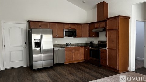 A kitchen with wooden cabinets and a stainless steel refrigerator.