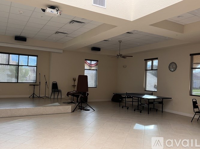 A room with a piano, a chair, and a table is available for rent.
