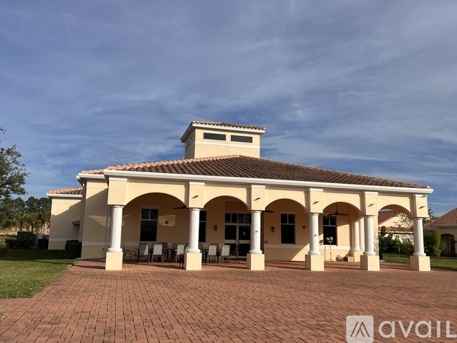 A white house with a red roof and a balcony.