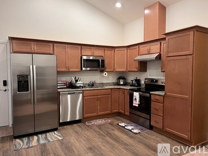 A kitchen with wooden cabinets and a stainless steel refrigerator.