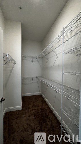 Empty walk in closet with white shelving.