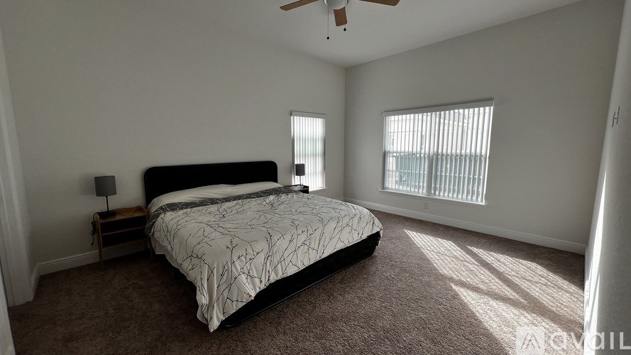 A bedroom with a large bed and a ceiling fan.