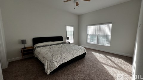A bedroom with a large bed and a ceiling fan.