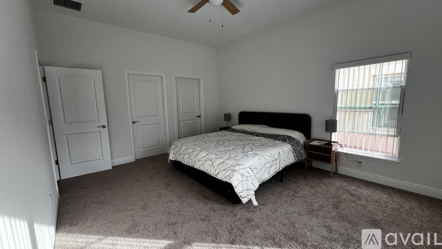 A bedroom with a bed, dresser, and window.