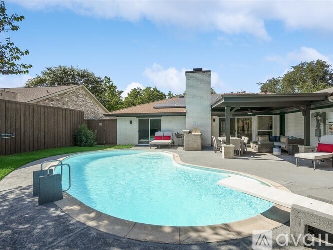 A backyard with a pool and a house.