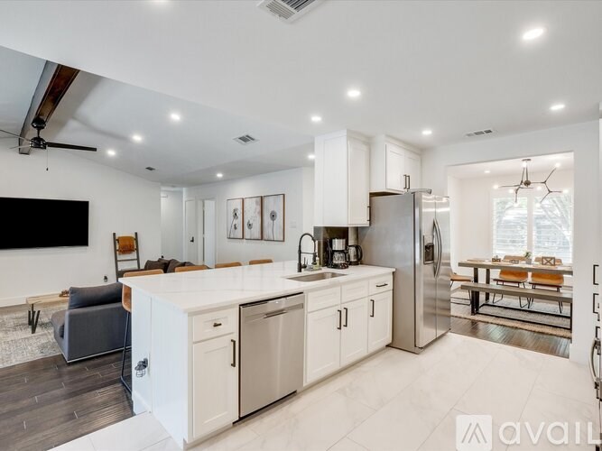 A modern kitchen with white cabinets and stainless steel appliances.