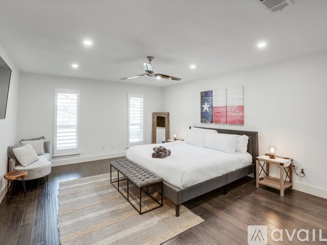 A bedroom with a large bed and a ceiling fan.