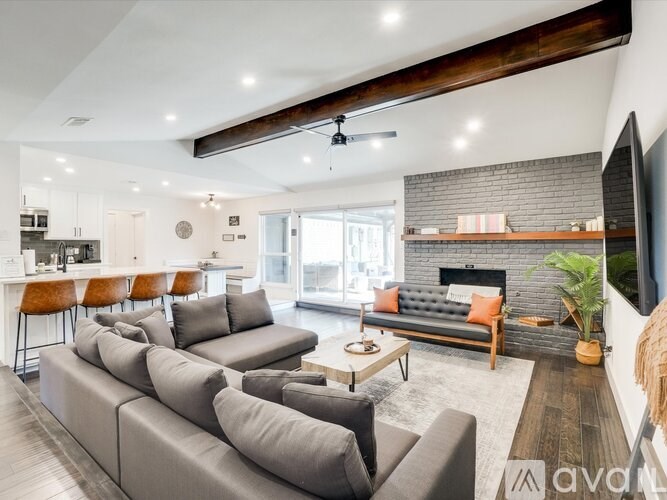 A modern living room with a grey sofa set and a fireplace.