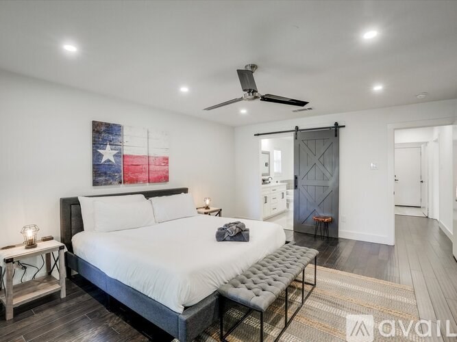 A bedroom with a large bed and a Texas flag on the wall.