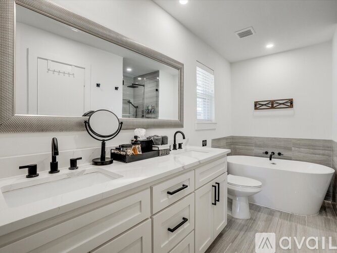 A bathroom with a white tub, sink, and toilet.