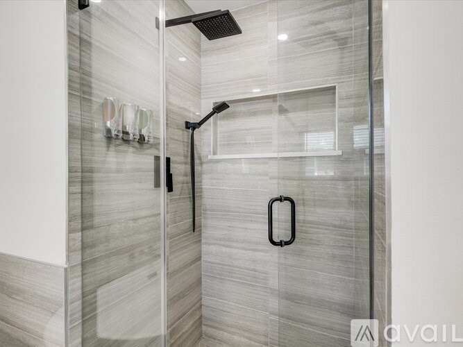 A modern bathroom with a glass shower stall and a glass door.