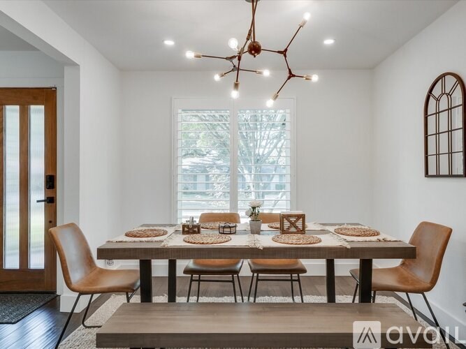 A modern dining room with a large table set for a meal.