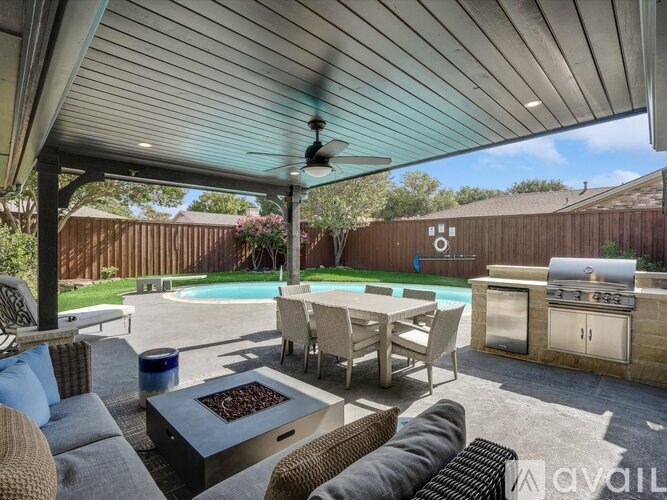 A patio with a table, chairs, and a pool.