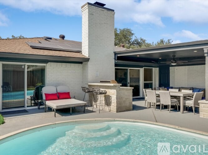 A pool in a backyard with a patio and a fireplace.