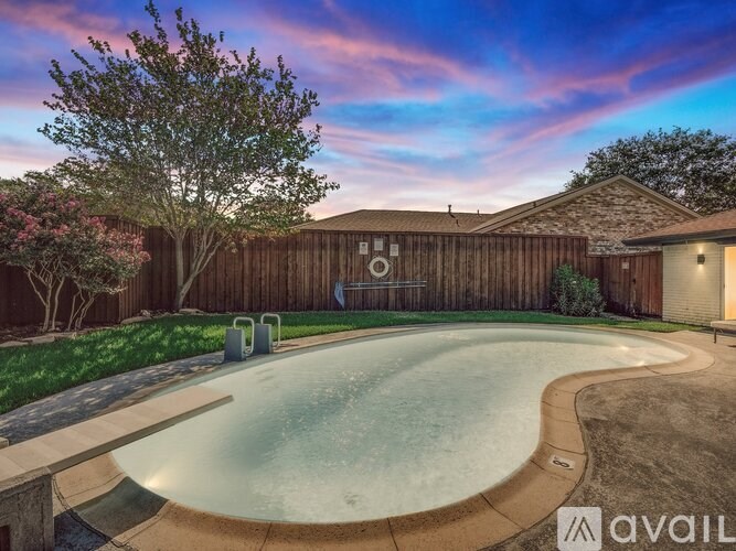 A backyard with a pool and a wooden fence.