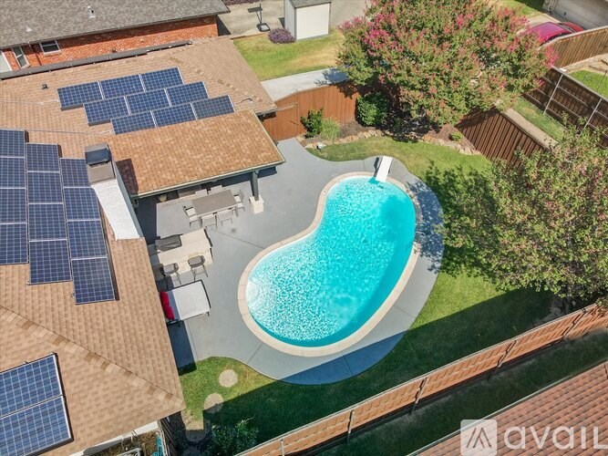 A house with a pool and solar panels on the roof.