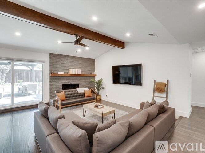 A living room with a grey couch and a fireplace.