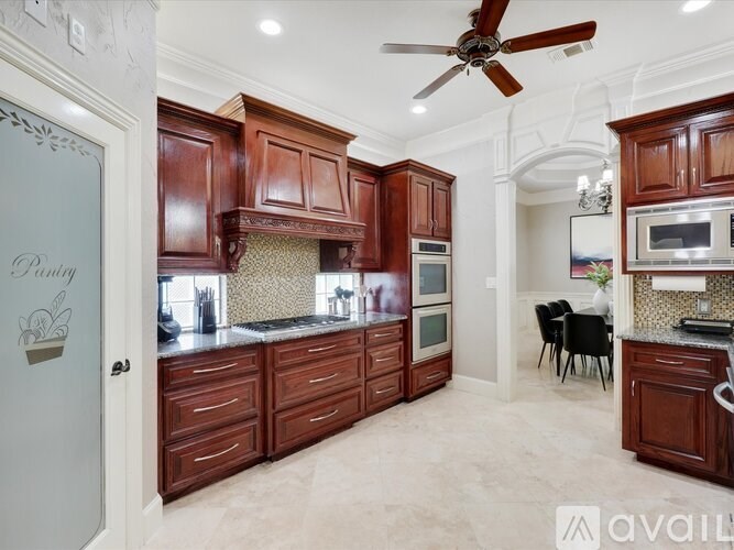 A kitchen with brown cabinets and a ceiling fan.