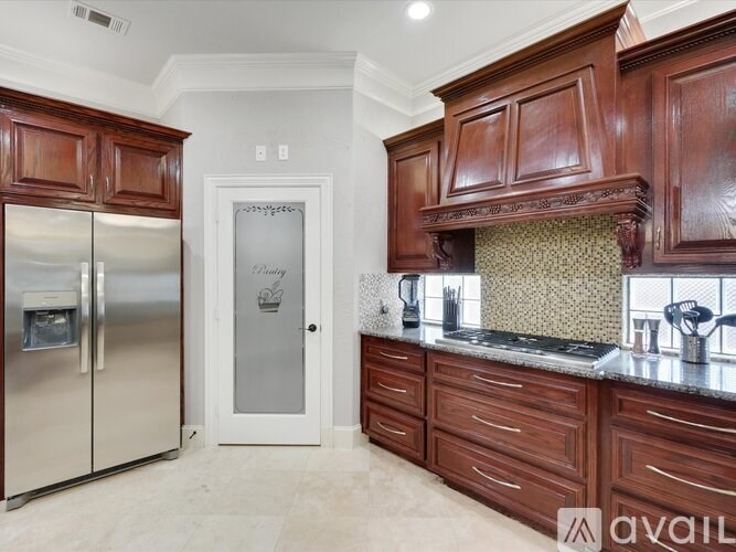 A kitchen with wooden cabinets and a stainless steel refrigerator.