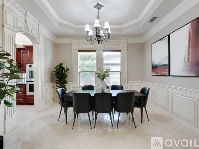 A dining room with a large table and chairs.