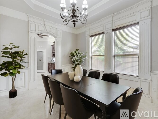 A dining room with a large table and chairs.