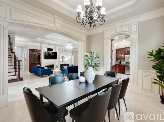 A dining room with a large table and chairs.