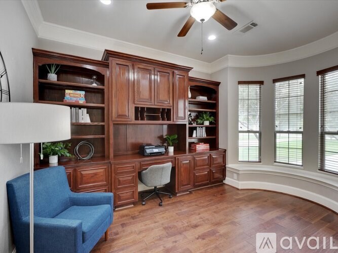 A room with a blue chair and wooden furniture.
