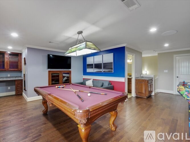 A pool table in a room with a TV and a fireplace.