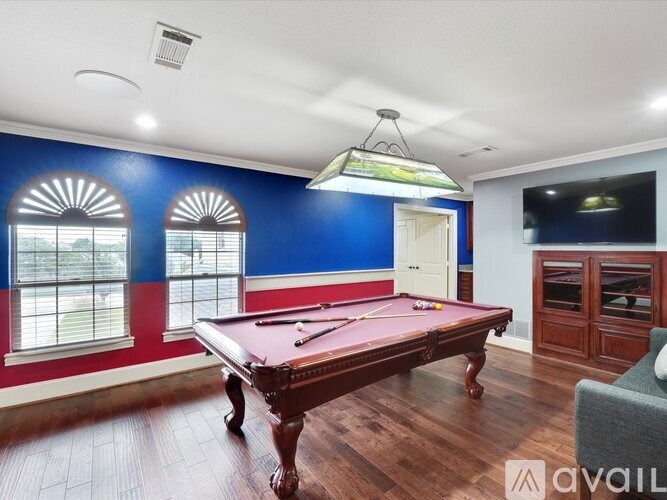 A pool table in a room with blue and red walls.
