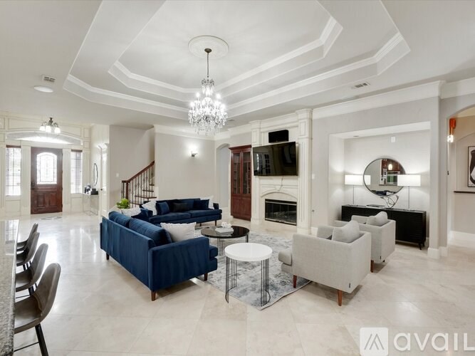 A living room with a blue sofa and a chandelier.