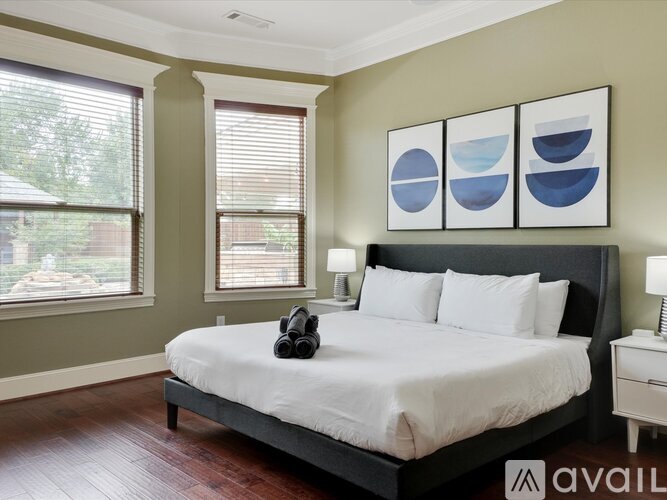 A bedroom with a large bed and a pair of headphones on the bed.
