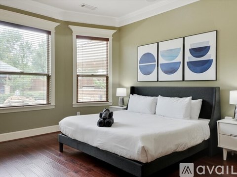 A bedroom with a large bed and a pair of headphones on the bed.