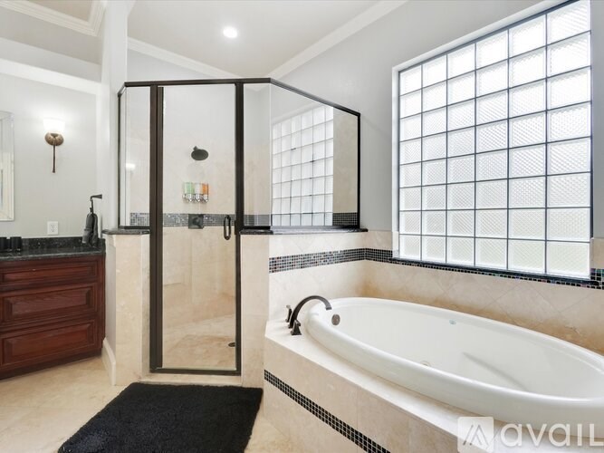 A modern bathroom with a large tub and a walk-in shower.