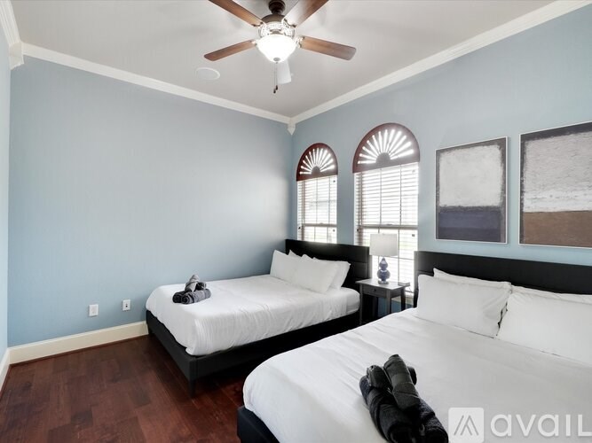 A bedroom with two beds and a ceiling fan.
