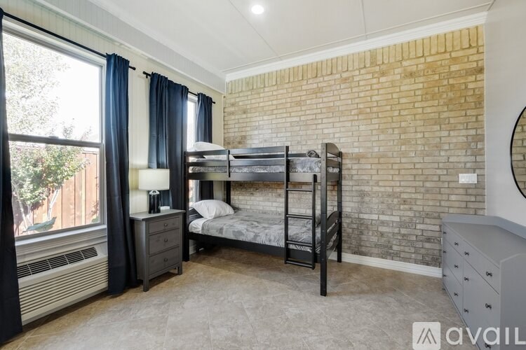 A bedroom with a brick wall and a bunk bed.