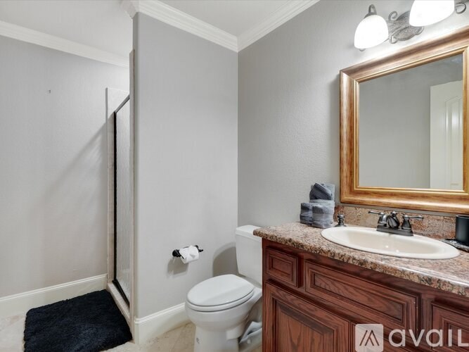 A bathroom with a toilet, sink, and mirror.
