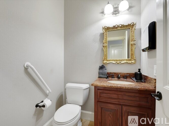 A bathroom with a toilet, sink, and mirror.